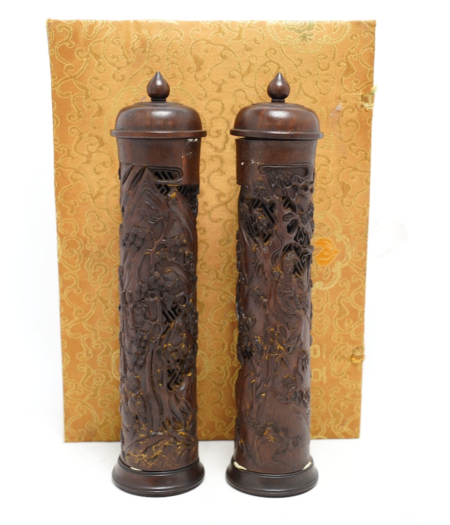 A pair of Chinese hardwood incense holders carved with trees and figures, cased, 29cm high. Condition - good